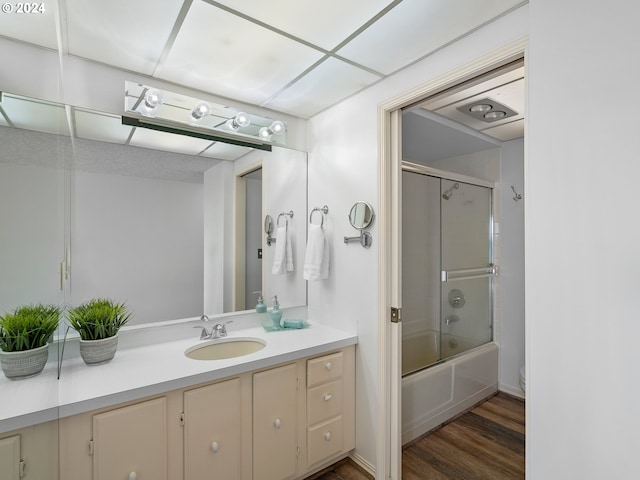 full bath featuring shower / bath combination with glass door, vanity, toilet, and wood finished floors