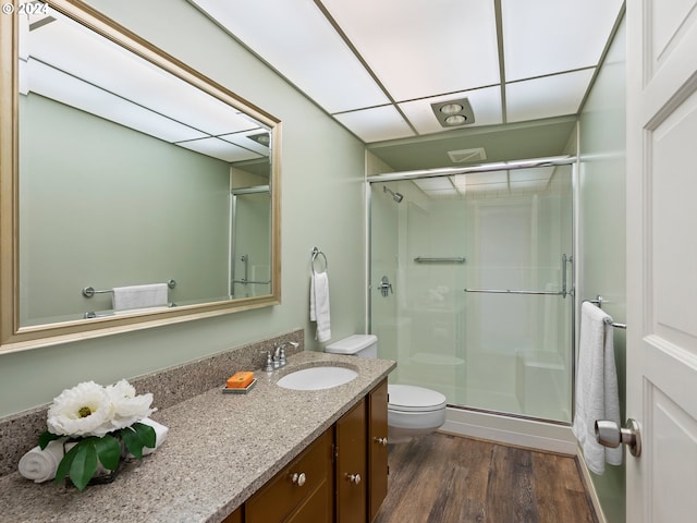 full bathroom with toilet, a shower stall, wood finished floors, and vanity