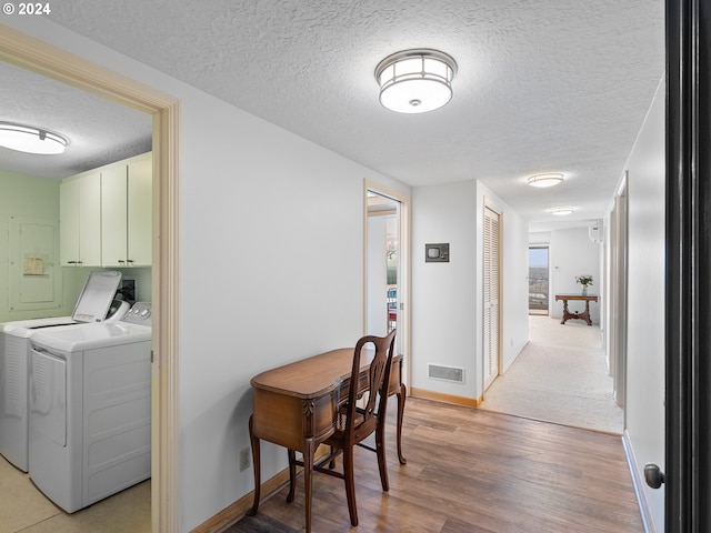 corridor featuring hardwood / wood-style floors, independent washer and dryer, and a textured ceiling