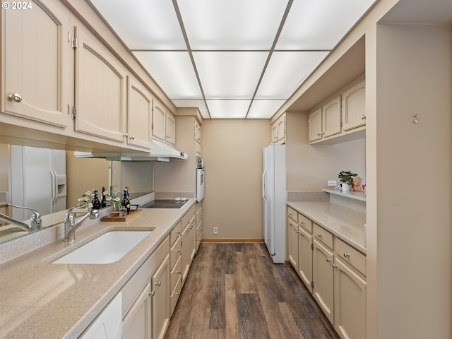 kitchen featuring dark wood-type flooring, white appliances, a sink, and baseboards