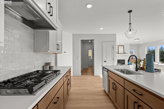 kitchen with pendant lighting, sink, decorative backsplash, white cabinetry, and stainless steel appliances