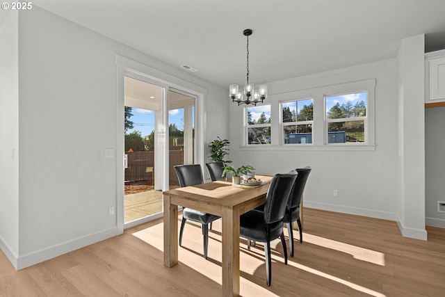 dining area featuring a chandelier, light hardwood / wood-style floors, and plenty of natural light