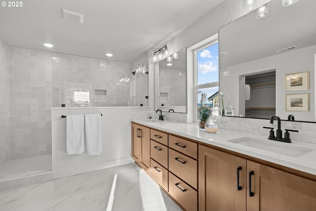 bathroom with vanity and tiled shower