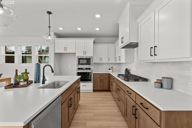 kitchen featuring white cabinets, pendant lighting, sink, and stainless steel appliances