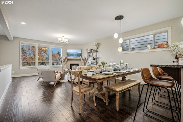 dining room with dark hardwood / wood-style floors and a notable chandelier