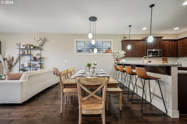 dining space featuring sink and dark wood-type flooring