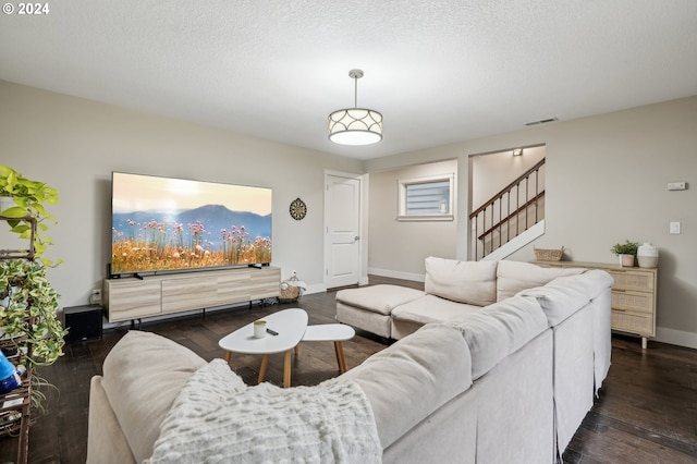 living room featuring a textured ceiling and dark hardwood / wood-style floors