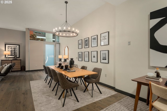 dining space with baseboards, a chandelier, and wood finished floors