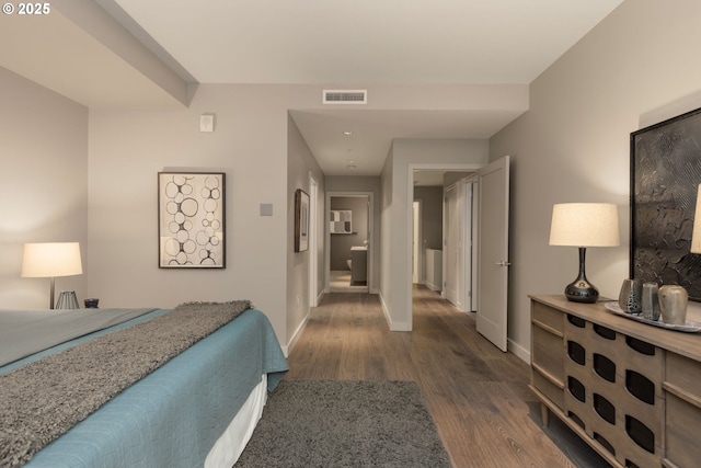 bedroom with dark wood finished floors, visible vents, and baseboards