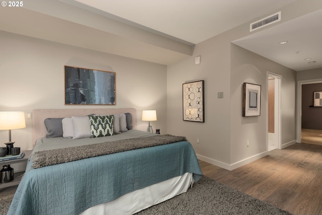 bedroom featuring baseboards, visible vents, and wood finished floors