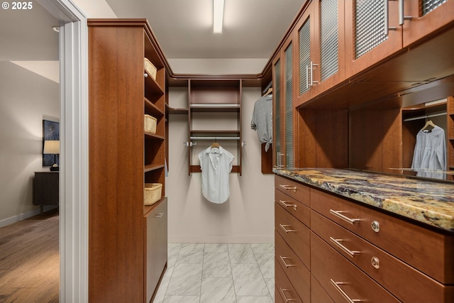 walk in closet with marble finish floor