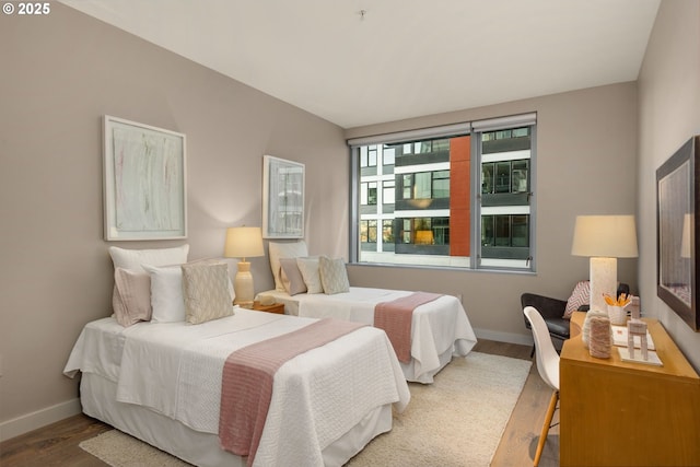 bedroom with baseboards and wood finished floors