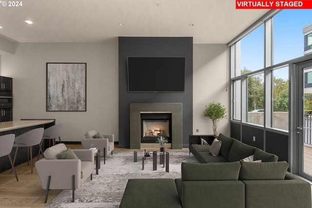 living room featuring a large fireplace and light hardwood / wood-style floors