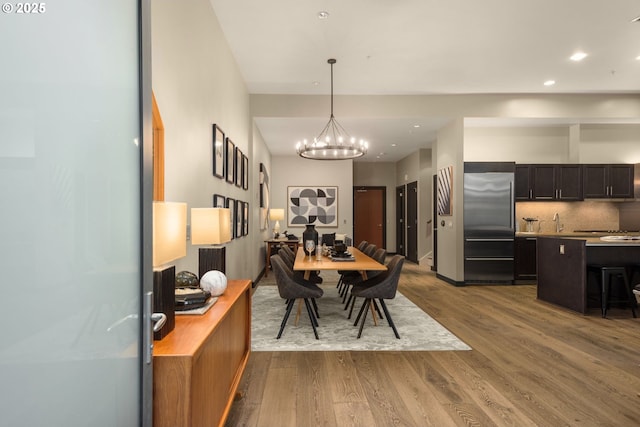 dining room featuring dark wood-style flooring, recessed lighting, and an inviting chandelier