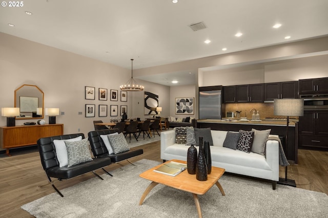 living area featuring a chandelier, recessed lighting, visible vents, and wood finished floors