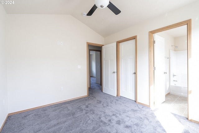 unfurnished bedroom with lofted ceiling, light colored carpet, connected bathroom, and ceiling fan