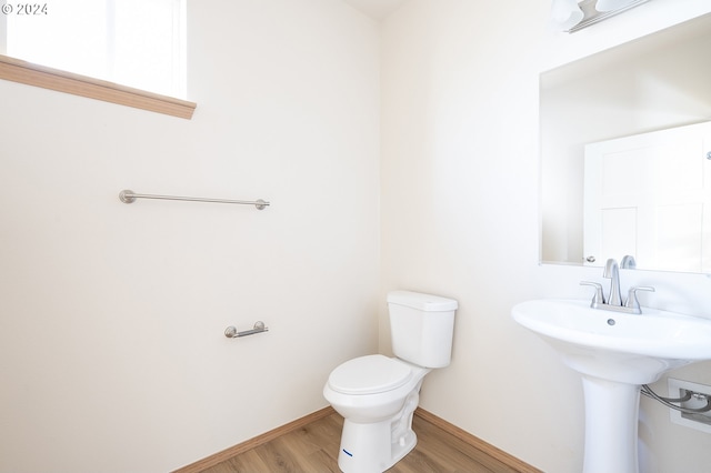 bathroom with hardwood / wood-style flooring and toilet