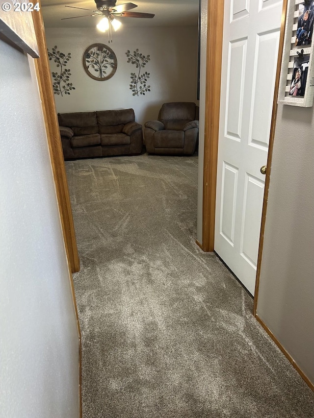 unfurnished living room with carpet and ceiling fan