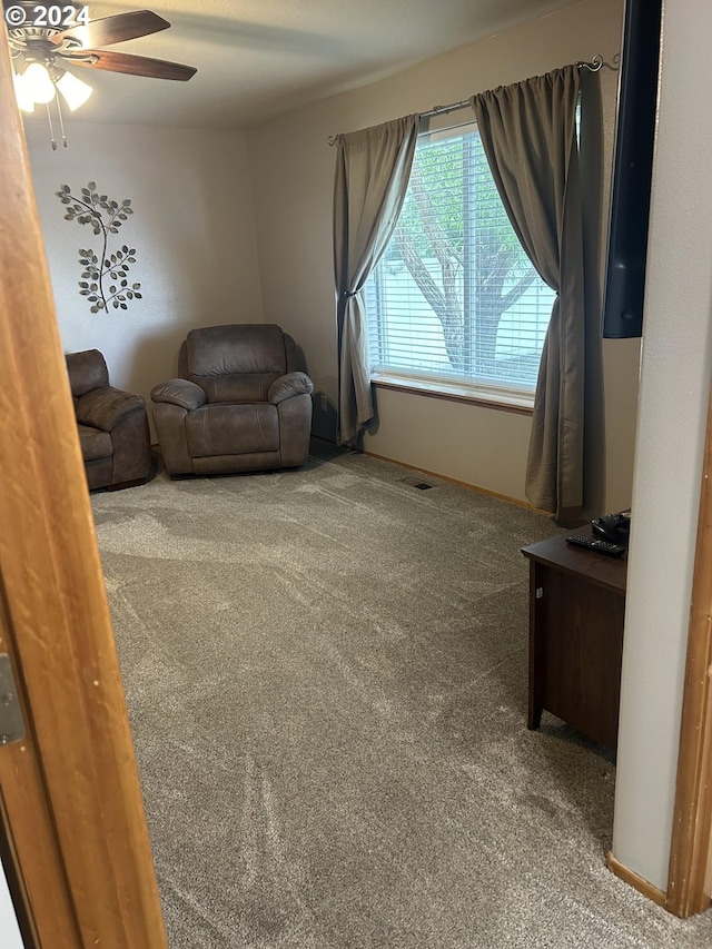 carpeted living room with ceiling fan