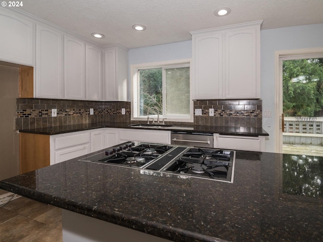 kitchen with white cabinets, gas cooktop, dishwasher, and sink