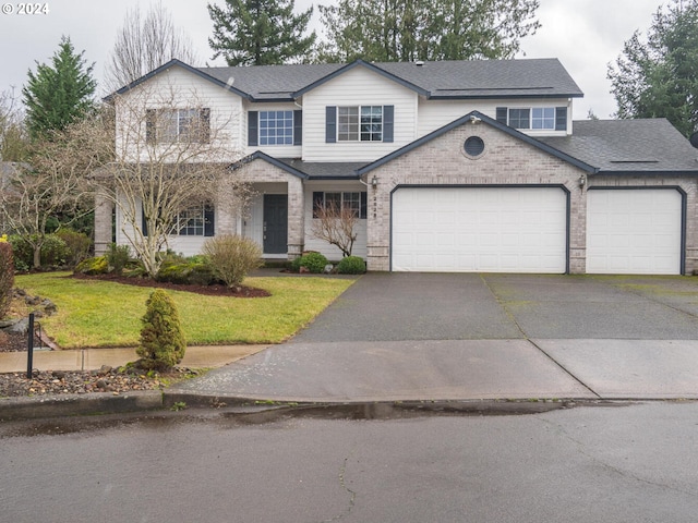 view of front of home with a front yard and a garage