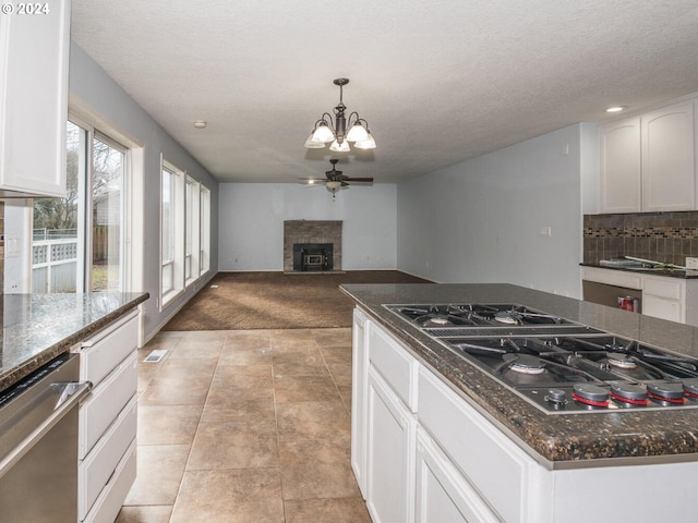 kitchen with white cabinetry, dishwasher, black gas stovetop, a textured ceiling, and ceiling fan with notable chandelier