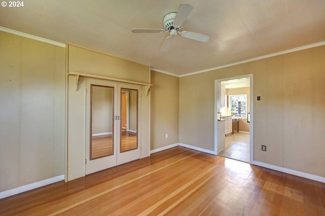 empty room with ceiling fan, hardwood / wood-style flooring, and crown molding