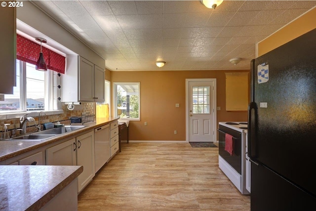 kitchen with white cabinetry, white appliances, tasteful backsplash, sink, and light hardwood / wood-style floors