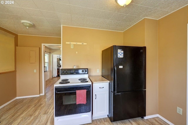 kitchen featuring white electric stove, ornamental molding, black fridge, light wood-type flooring, and white cabinets