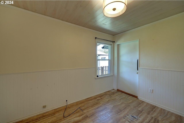 spare room featuring light wood-type flooring, wooden ceiling, and ornamental molding