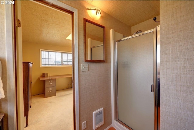 bathroom featuring a textured ceiling and a shower with shower door