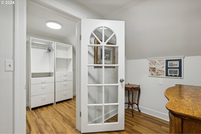 walk in closet featuring lofted ceiling and light hardwood / wood-style floors