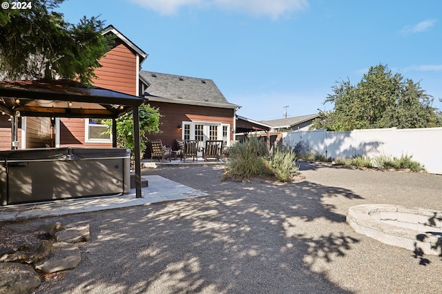 view of yard featuring a patio area, a hot tub, and french doors