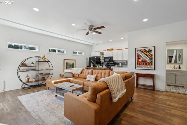 living room with dark wood-type flooring, ceiling fan, and sink