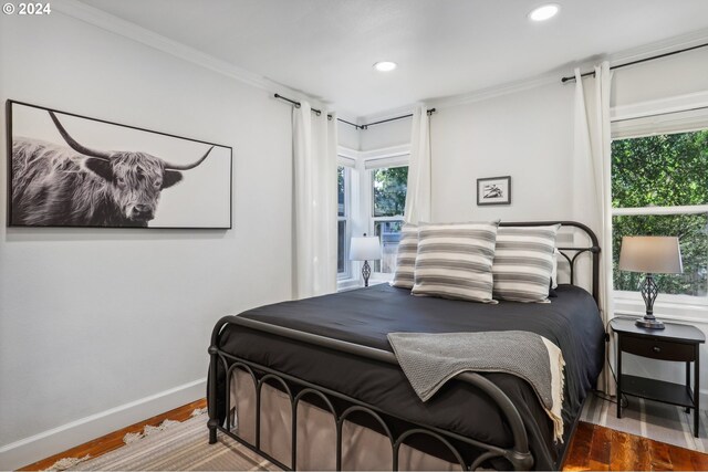 bedroom featuring crown molding and dark hardwood / wood-style flooring