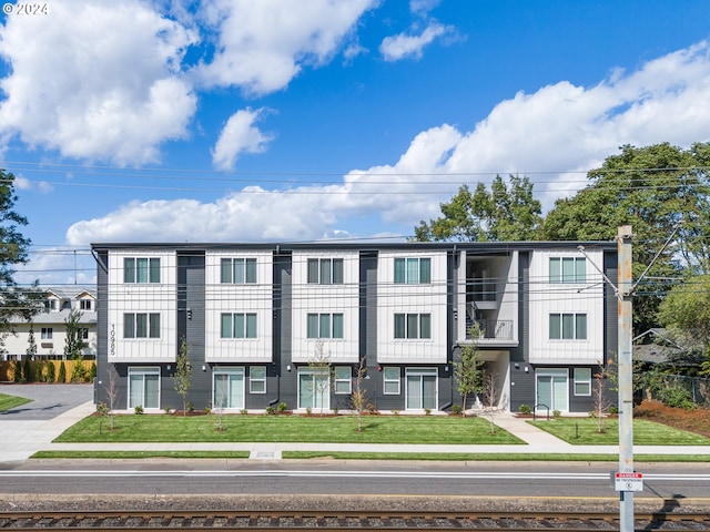 townhome / multi-family property featuring a front lawn