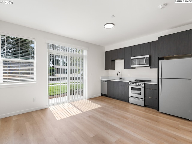 kitchen featuring sink, stainless steel appliances, a wealth of natural light, and light hardwood / wood-style flooring