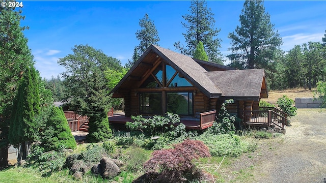 view of front facade featuring a shingled roof and log exterior