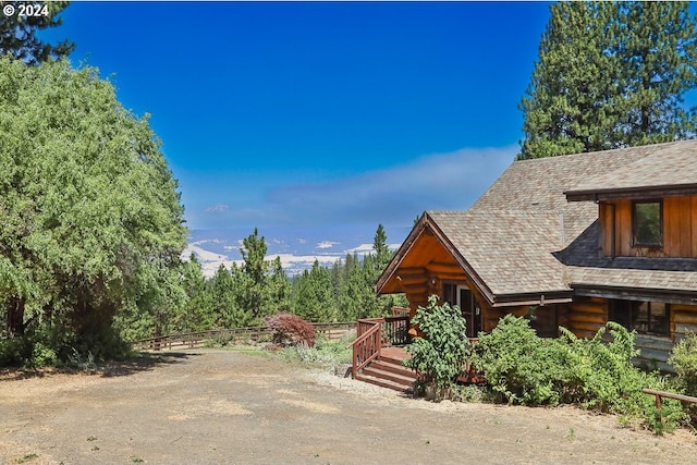 view of side of home featuring log siding and a wooden deck