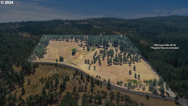 birds eye view of property featuring a rural view and a wooded view