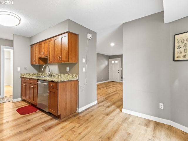 kitchen featuring light stone countertops, dishwasher, sink, light hardwood / wood-style flooring, and a textured ceiling