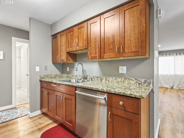 kitchen with sink, dishwasher, light stone counters, and light wood-type flooring