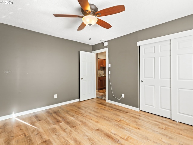 unfurnished bedroom featuring ceiling fan, a closet, and light hardwood / wood-style flooring