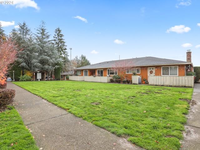 ranch-style home with a shed and a front yard