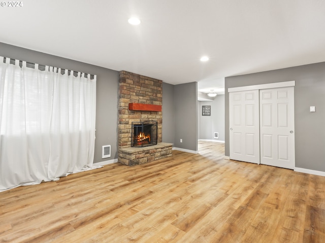 unfurnished living room with a fireplace and light hardwood / wood-style floors