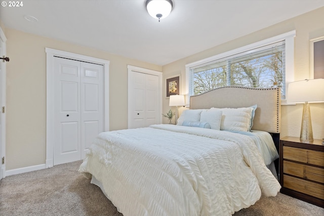 carpeted bedroom featuring two closets