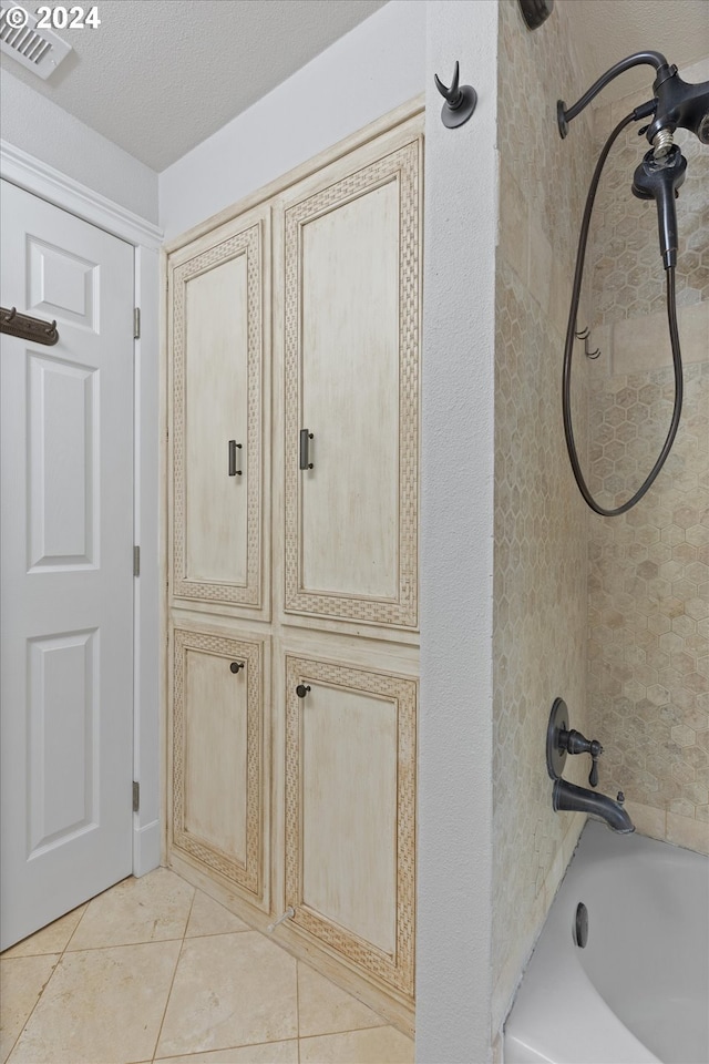 interior space with tile patterned flooring, a textured ceiling, and tiled shower / bath