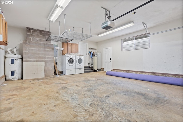 garage featuring washing machine and clothes dryer, water heater, and a garage door opener