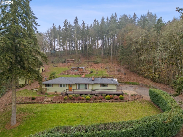 view of front facade featuring a front yard and a wooden deck