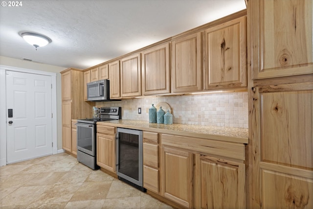 kitchen featuring light brown cabinets, backsplash, a textured ceiling, appliances with stainless steel finishes, and beverage cooler